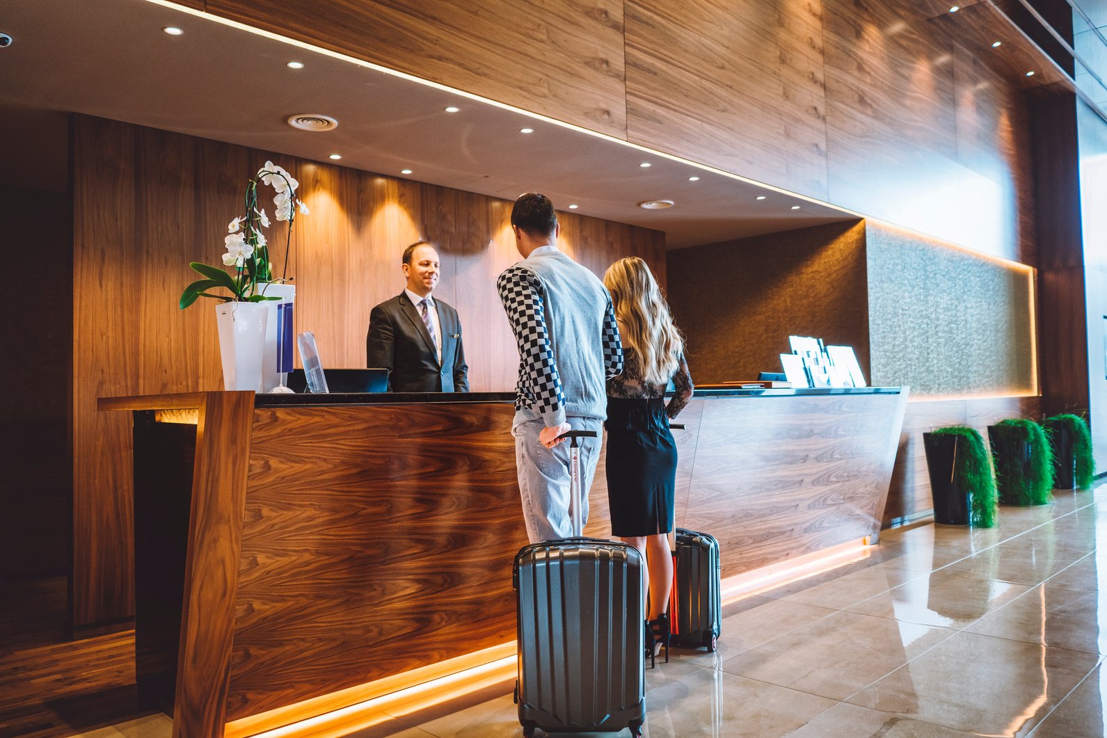 Hotel receptionist helping couple with the check-in